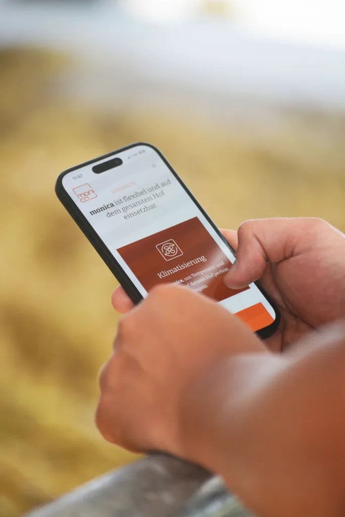 Hände tippen am Smartphone in der monica App